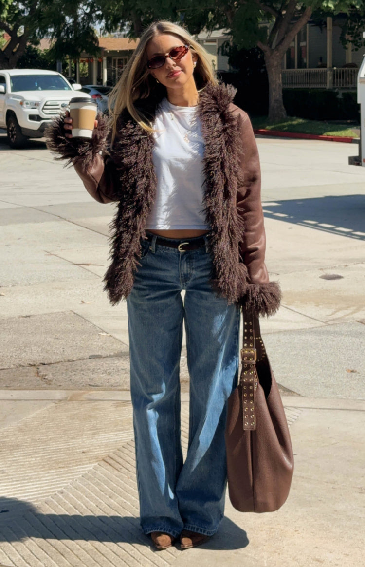 Brown faux leather jacket with shaggy fur trim extending down the lapels and around the cuffs