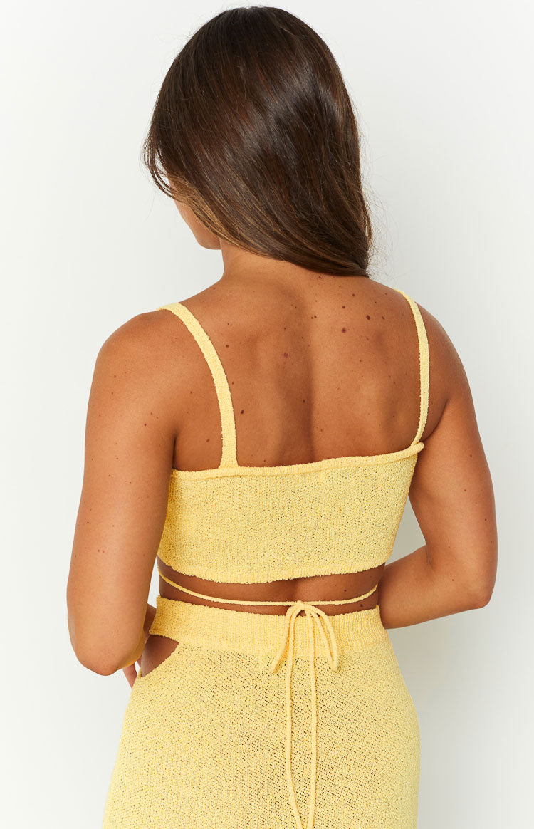 Rear view of a yellow knit crop top with thin shoulder straps and tie-back waist detail