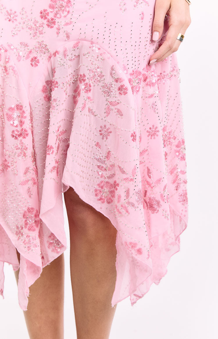 Detail shot of the pink midi dress hem, showing the handkerchief cut and floral sequin and bead patterns