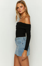 Side view of a black ribbed knit off-shoulder bodysuit with ruched detailing on the neckline and long sleeves