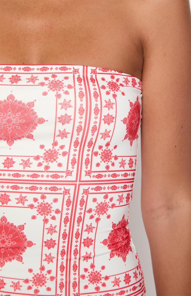 Close-up showing the strapless neckline and detailed red tile print of the white maxi dress