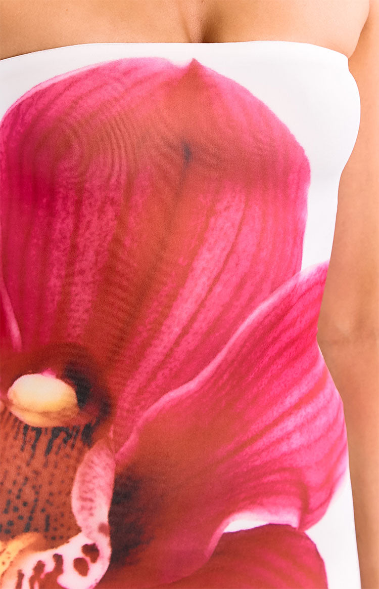 Close-up of the vibrant pink orchid print showing petal details on the white strapless maxi dress