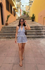 Blue plaid shorts with white lace trim along the hem, a relaxed fit, and subtle pleats
