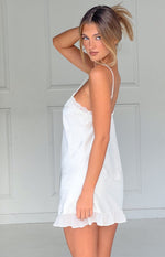 Side view of a cream satin mini dress with delicate lace trim neckline and ruffled hem