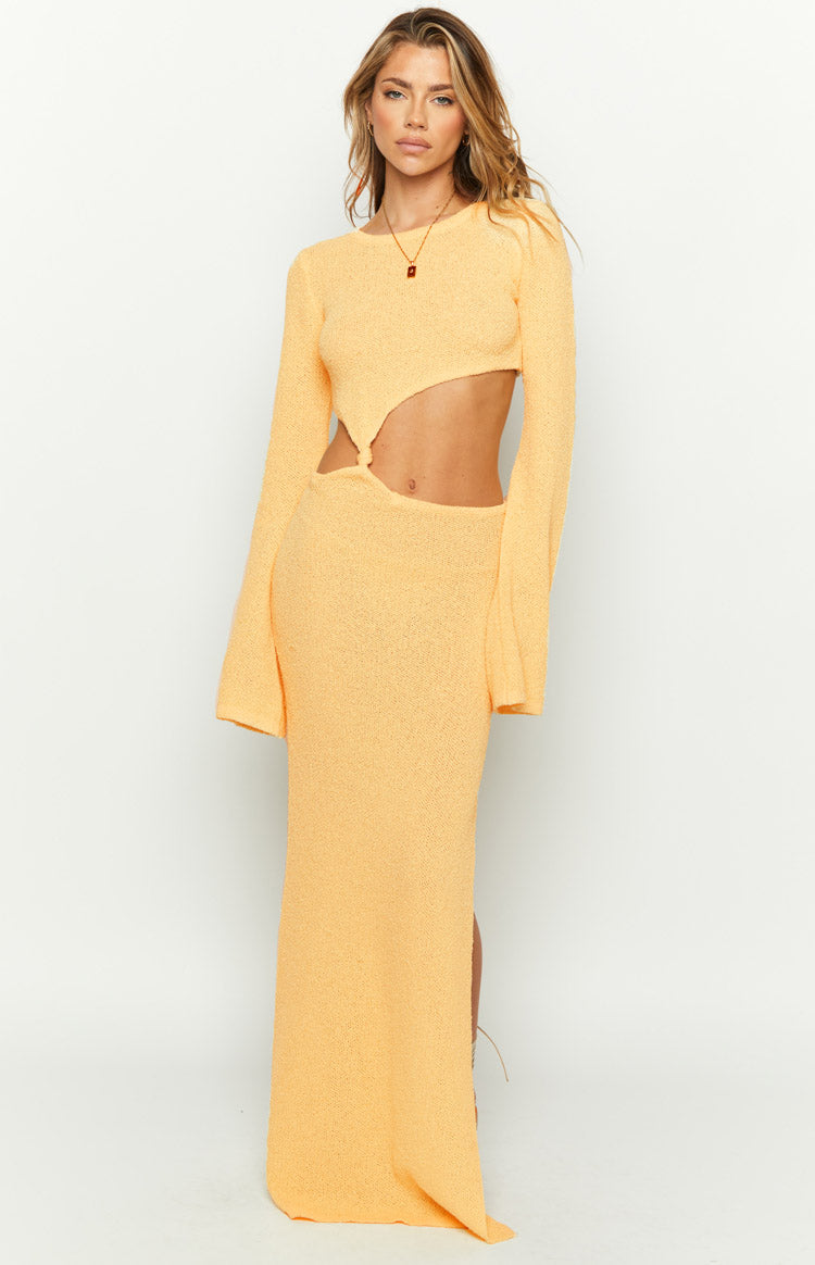 Front view of a yellow long sleeve knit maxi dress with a round neck, waist cutouts, and wide cuffs