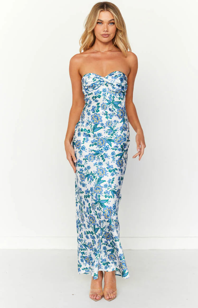 White strapless maxi dress with blue and green floral print, twisted sweetheart neckline, and a fitted silhouette