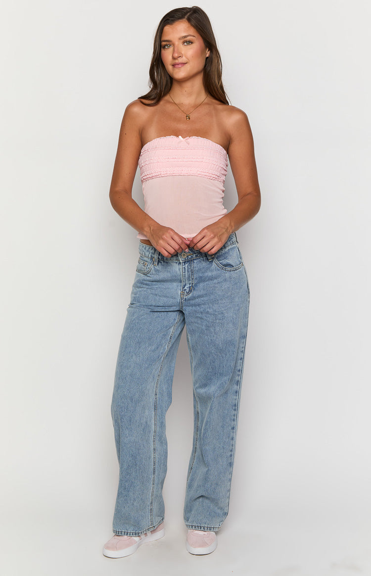Front view of a sheer pink strapless top with a ruffled shirred bust and fitted mesh body