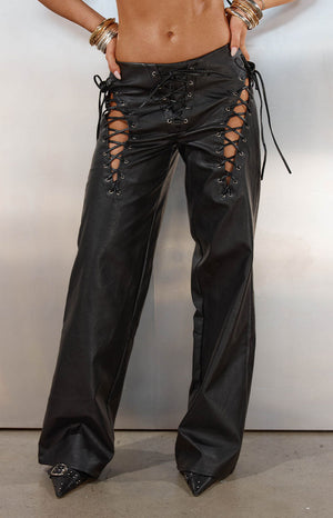 Model in a full black faux leather outfit with lace-up pants and a matching bralette ideal for a music Festival