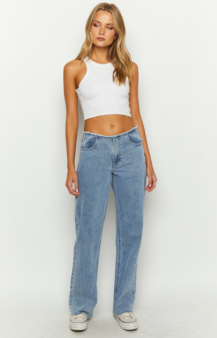 Front view of mid wash blue denim jeans with a raw edge mid-rise waist and relaxed straight leg fit