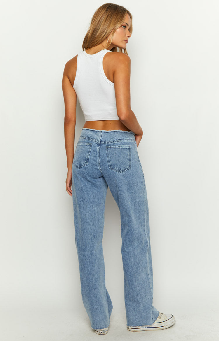 Rear view of mid wash blue denim jeans with a frayed mid-rise waistband and wide-leg fit