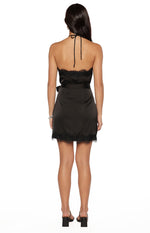 Rear view of a black satin halter neck mini dress with lace trim on the bodice and hem, showing the tie-back neck and waist