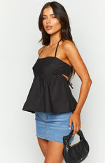 Side view of a black halter top showing the gathered peplum, side cutouts, and tie details