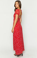Side view of a red floral maxi dress with an open back, tie details, and short puff sleeves