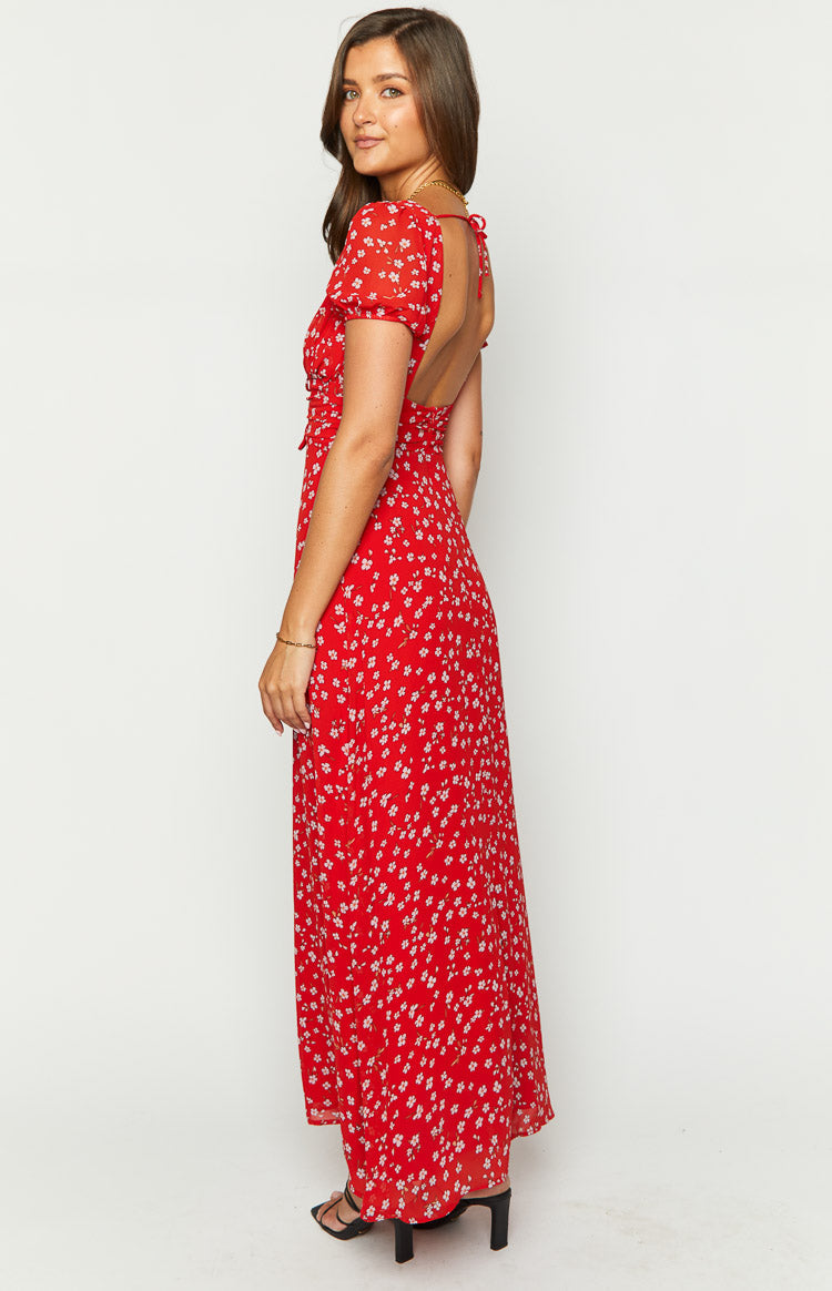 Side view of a red floral maxi dress with an open back, tie details, and short puff sleeves