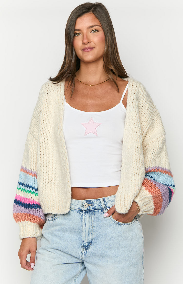 Front view of a cream chunky knit cardigan with colourful striped balloon sleeves
