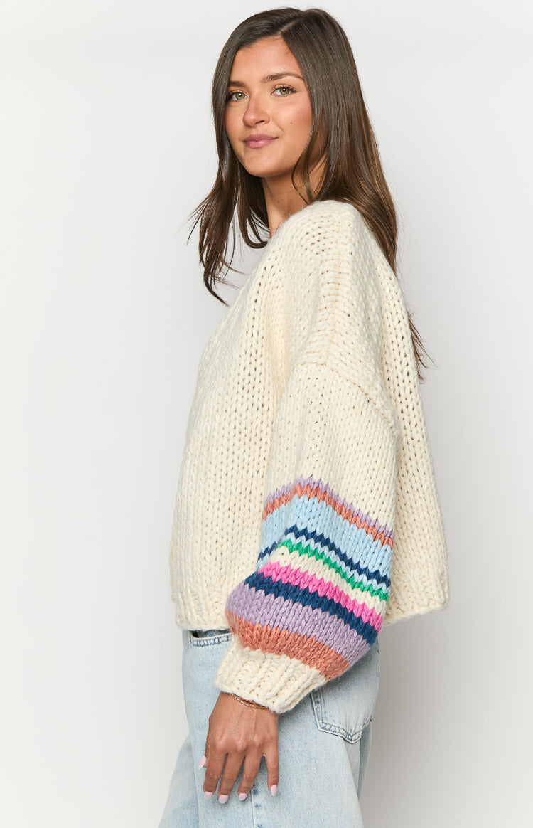 Side view of the cream chunky knit cardigan with a balloon sleeve featuring colourful stripes