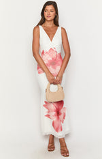 Front view of a white maxi dress with a V-neckline, ruched bust, and large pink floral print
