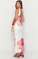 Side view showing the fitted silhouette of a white floral print maxi dress with a low scoop back and tie detail