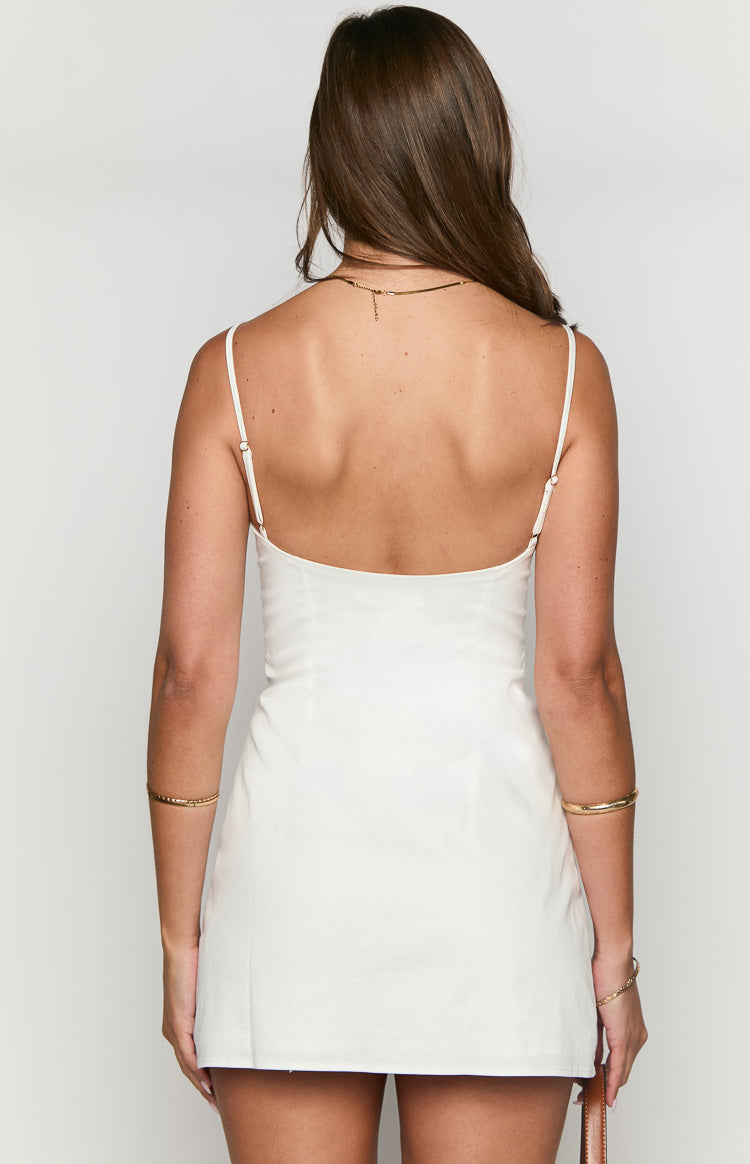 Rear view of a white mini dress with a low scoop back and thin adjustable spaghetti straps
