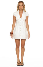 Front view of a white mini dress with a scalloped collar, puff sleeves, fitted bodice, and light brown button-front