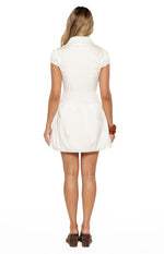 Rear view of a white collared mini dress with short puff sleeves and a flared pleated skirt