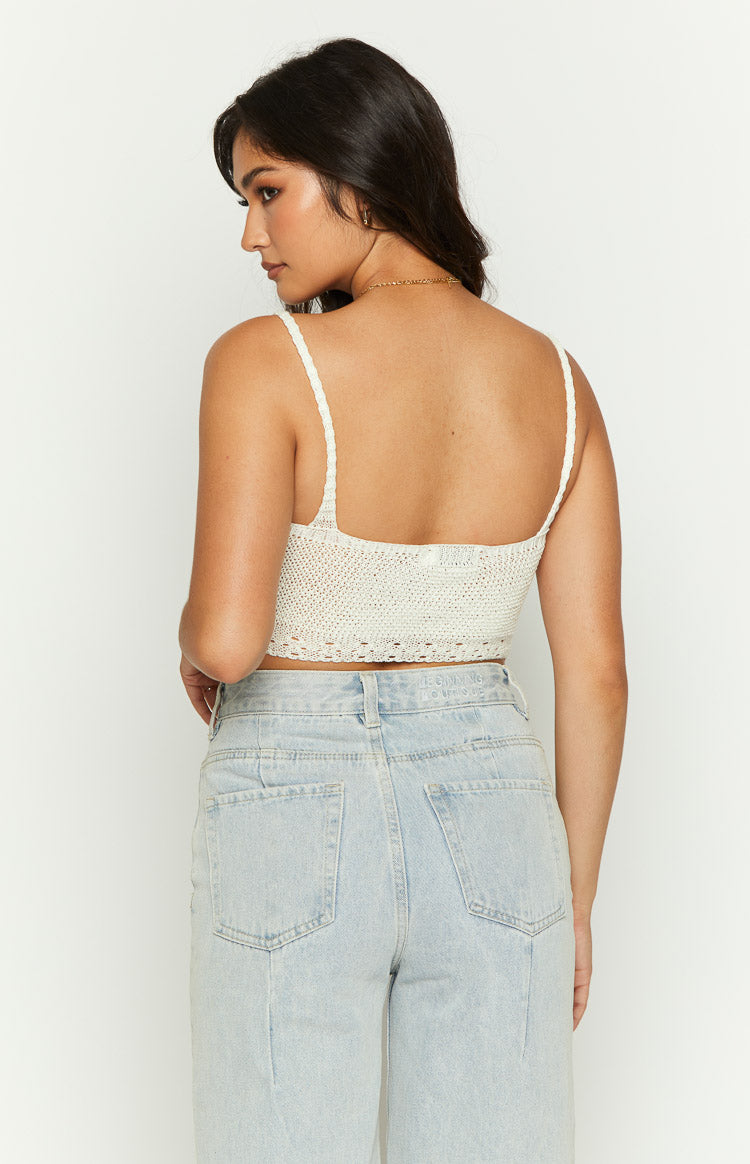 Rear view of a cream crochet crop top with thin braided straps and a straight backline