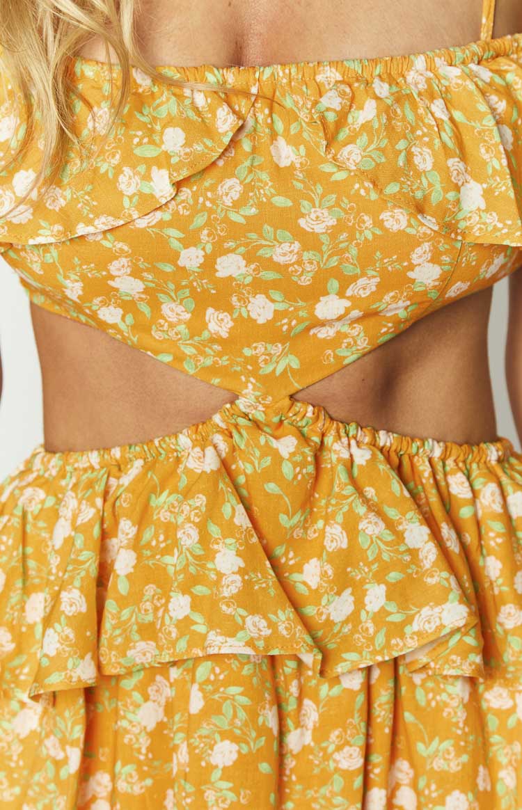 Close-up of the orange floral mini dress showing the triangular side cutouts and elasticated waist