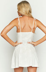 Rear view of a white mini dress with tie-up spaghetti straps and eyelet embroidery