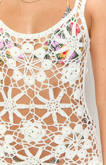 Close-up of the white crochet mini dress's open-knit floral and geometric patterns