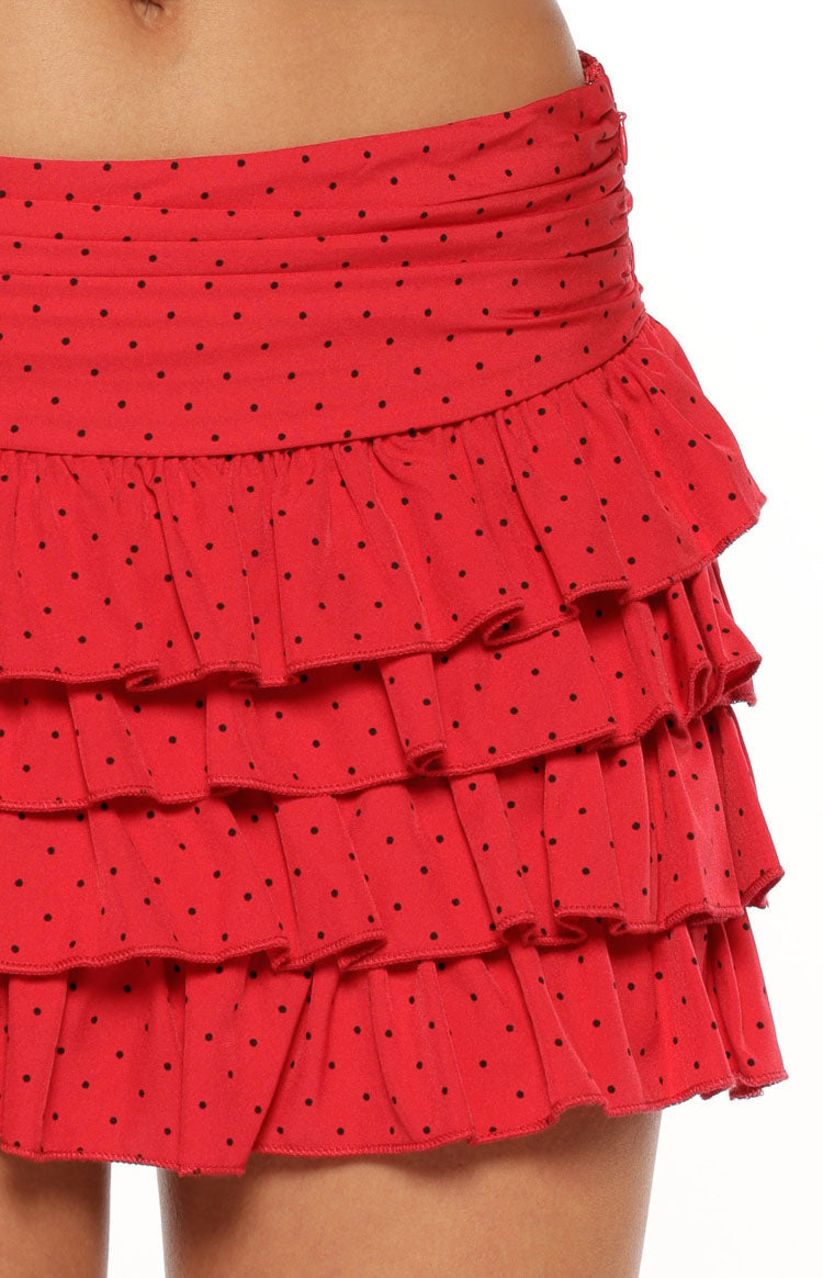 Side view of a red polka dot mini skirt showing the tiered ruffles and ruched waistband