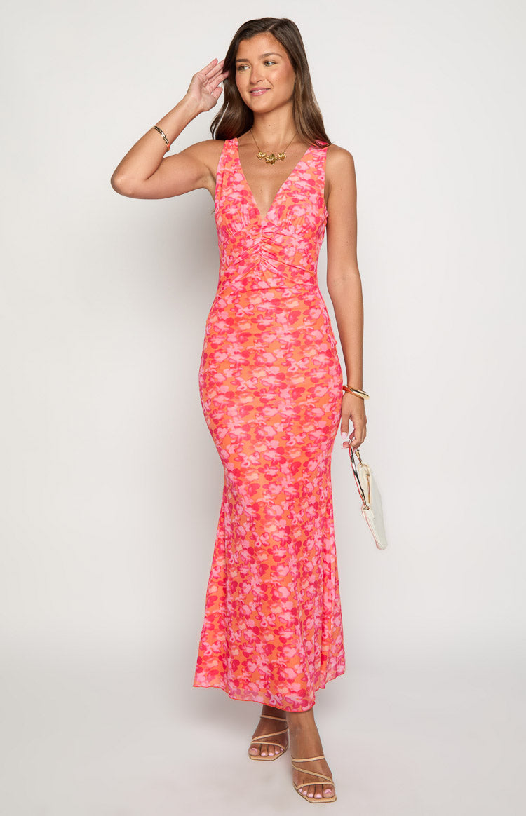 Front view of an orange and pink floral print maxi dress with a V-neck and ruched bodice
