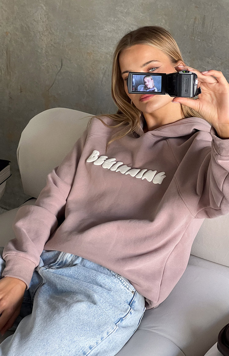 Close-up of the white raised bubble 'Beginning' text on a mauve oversized hoodie