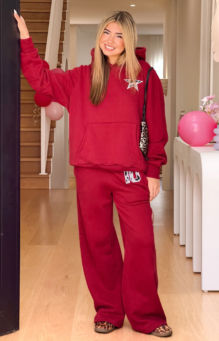 Full length view of an oversized burgundy hoodie with a leopard star and matching wide-leg sweatpants with a BB logo