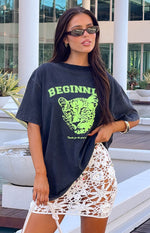 Washed black oversized tee with neon green 'BEGINNI' text and a leopard cub graphic print