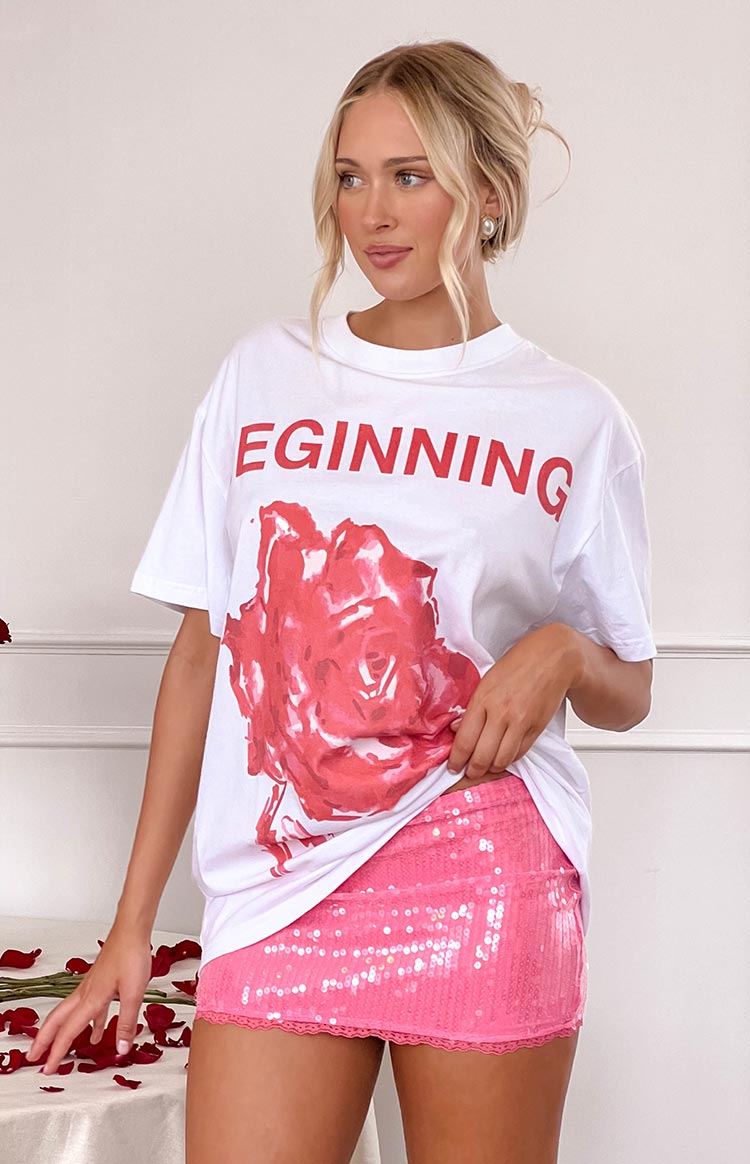 White oversized tee with a large red rose graphic and red EGINNING text on the chest