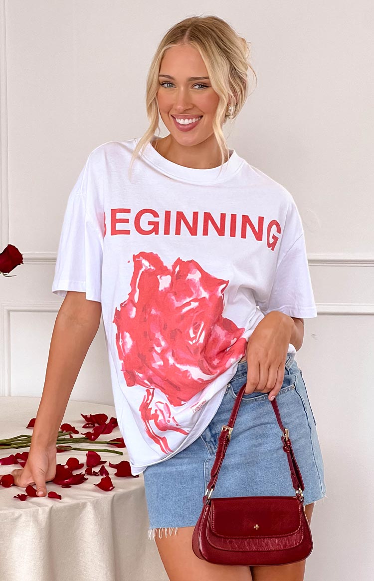 White oversized tee with red 'BEGINNING' text and a large red rose graphic print