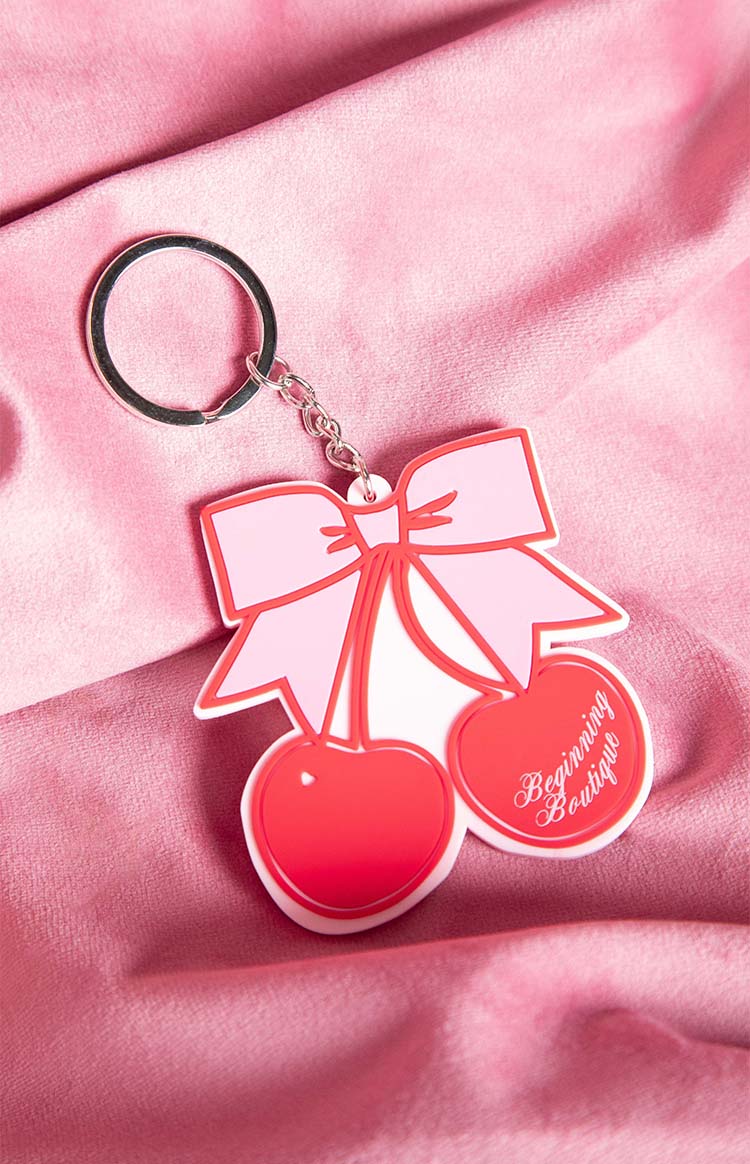 Close-up of the red and pink cherry bow keyring showing the Beginning Boutique text on one cherry