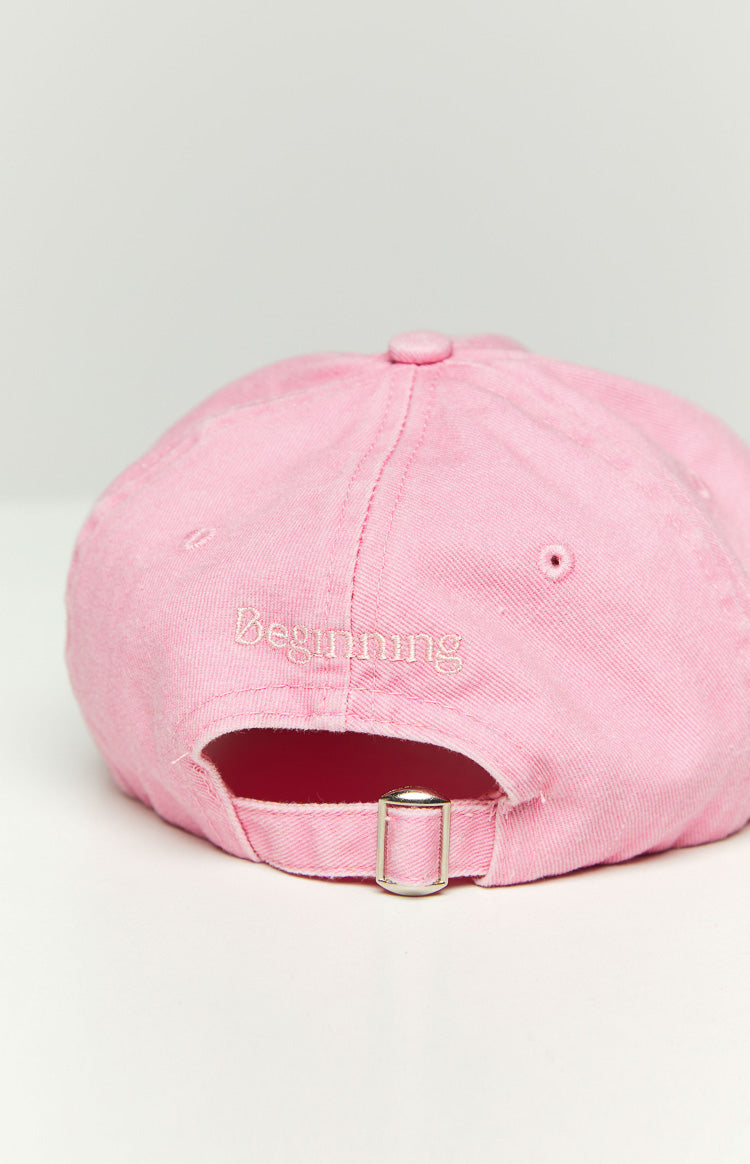 Close-up of the pink washed cap showing the embroidered "BEGINNING" text on the front and the distressed brim