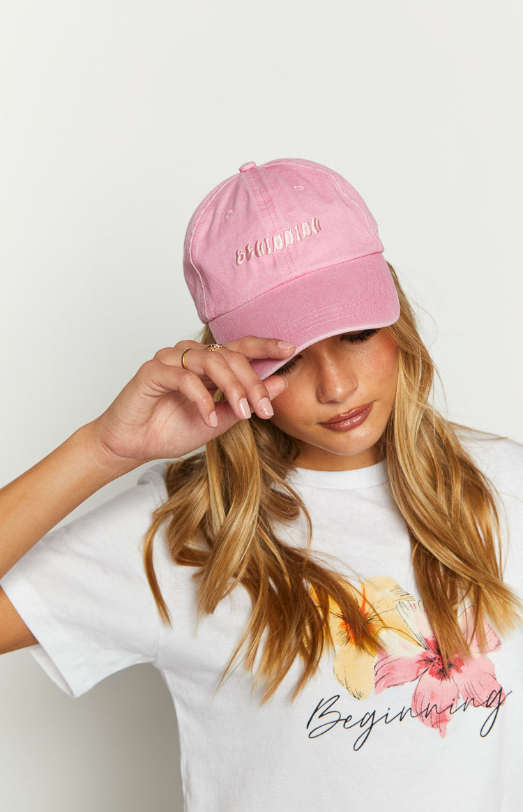 Rear view of a pink washed cap showing the embroidered Beginning text and silver adjustable buckle