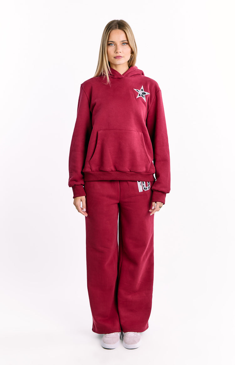 Full front view of a burgundy oversized hoodie with a relaxed fit, a leopard print star graphic, and a large kangaroo pocket