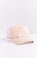 A cream trucker cap with a pink mesh back and pink embroidered 'Western' text above a horse motif