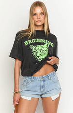 Black oversized tee with a neon green leopard graphic print and 'BEGINNING' text across the chest
