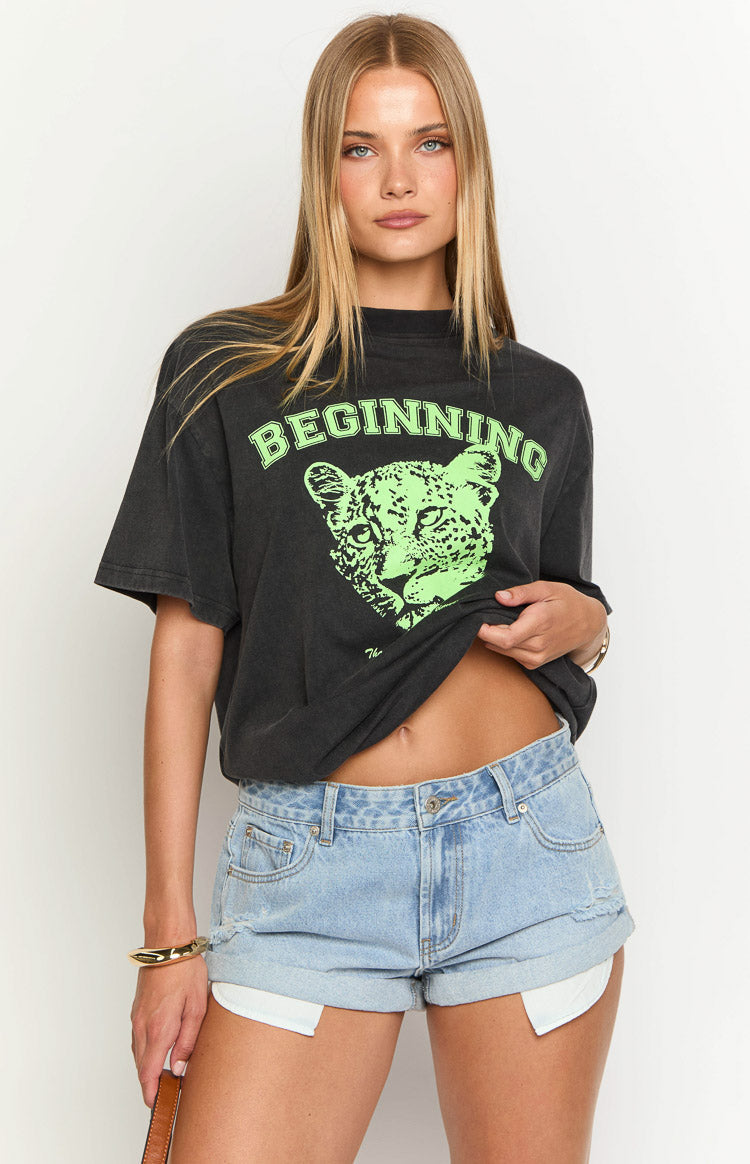 Black oversized tee with a neon green leopard graphic print and 'BEGINNING' text across the chest