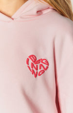 Close-up of the raised red heart graphic with stylized lettering on a light pink hoodie