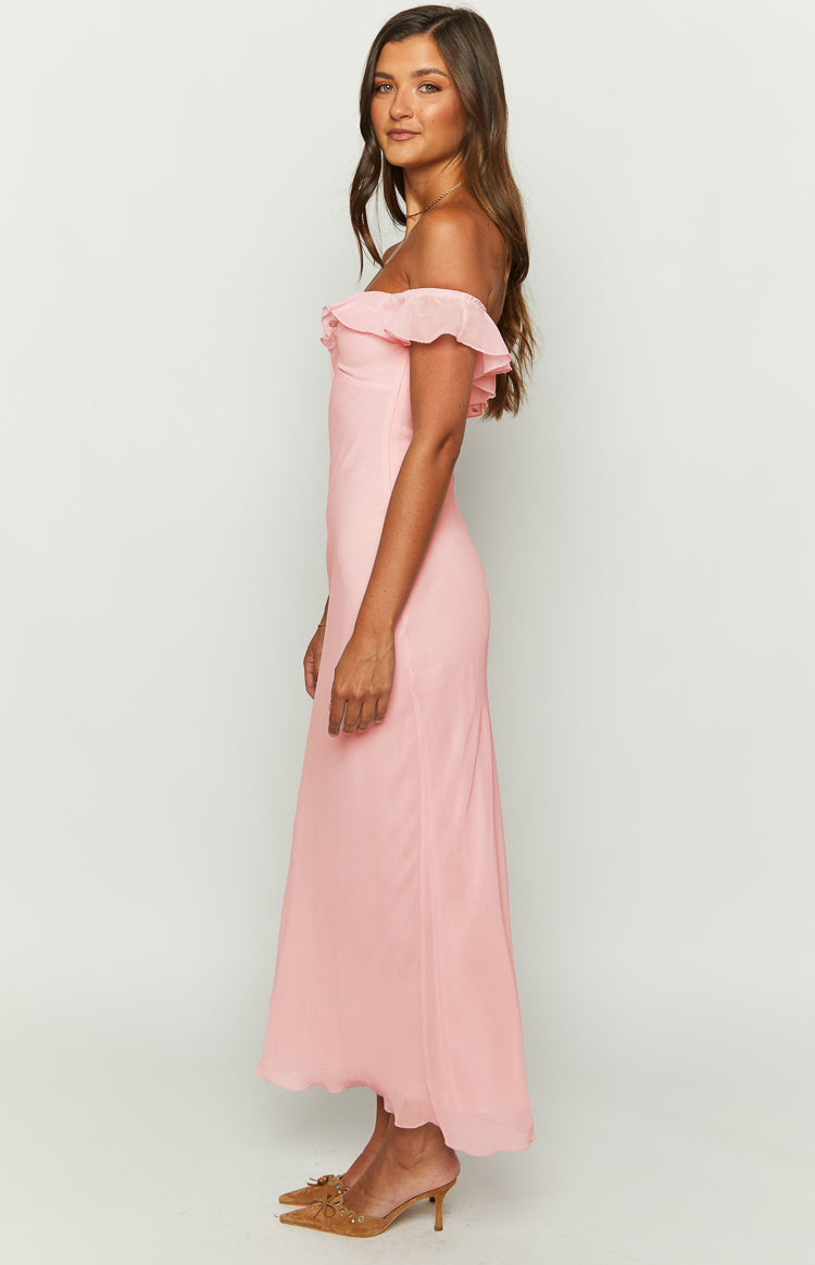 Side view of a pink chiffon maxi dress with an off-shoulder ruffled neckline and a flowing skirt