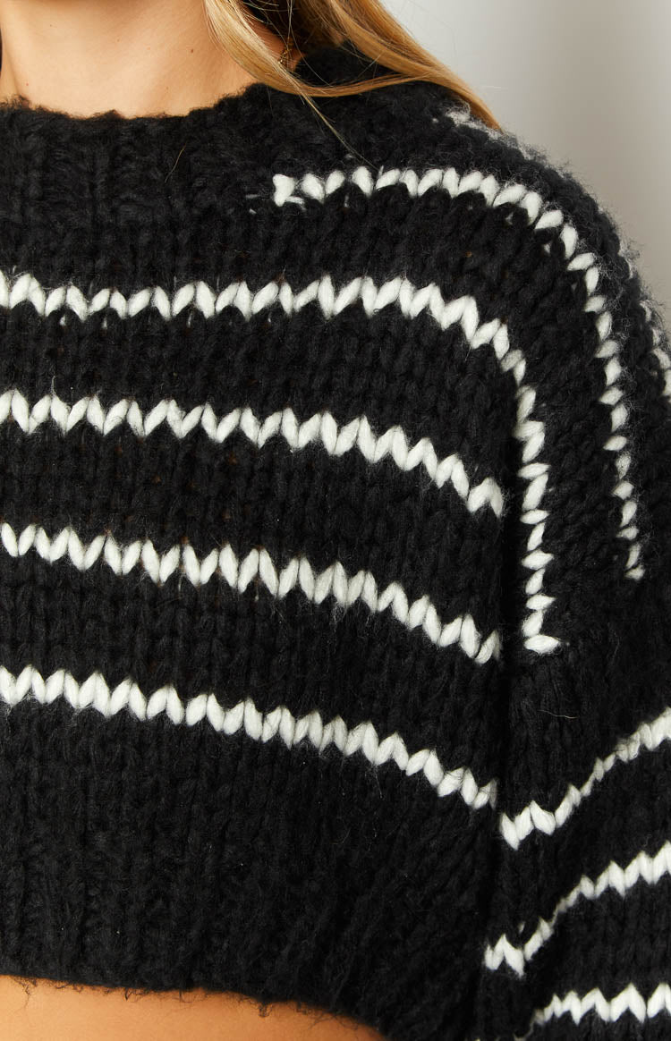 Rear view of the black and white striped knit sweater showing the cropped length and chunky knit texture