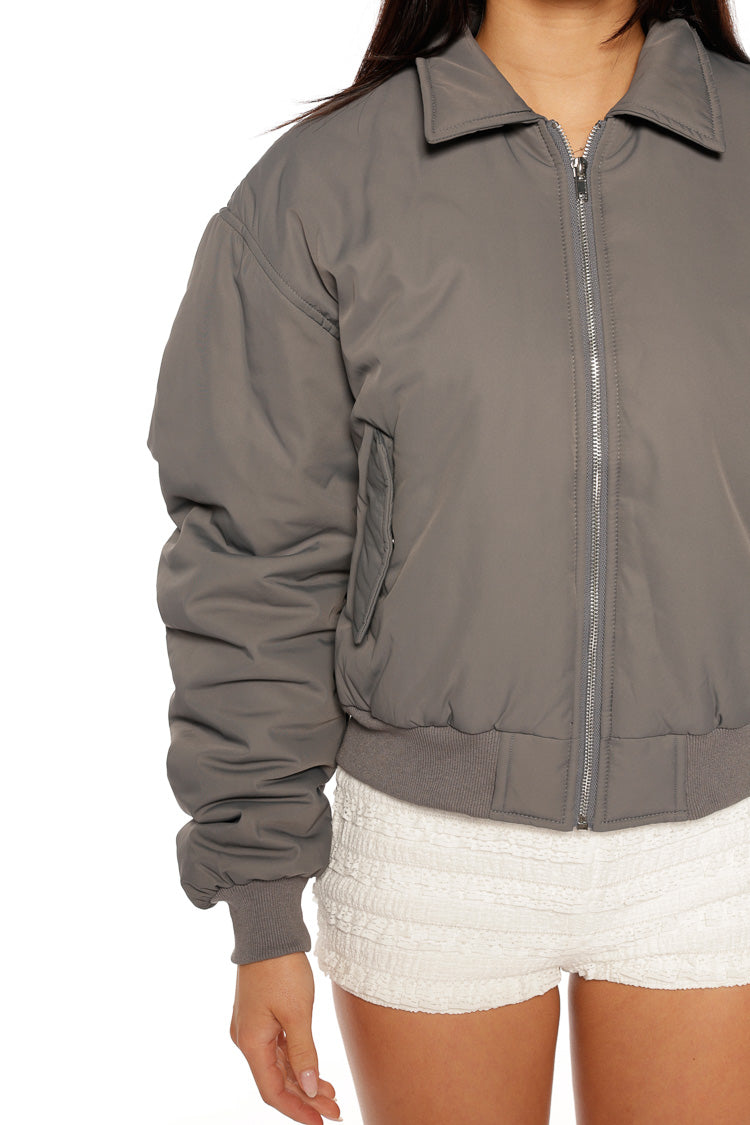 Close-up of the grey bomber jacket showing the puffed sleeve with ribbed cuff and hem