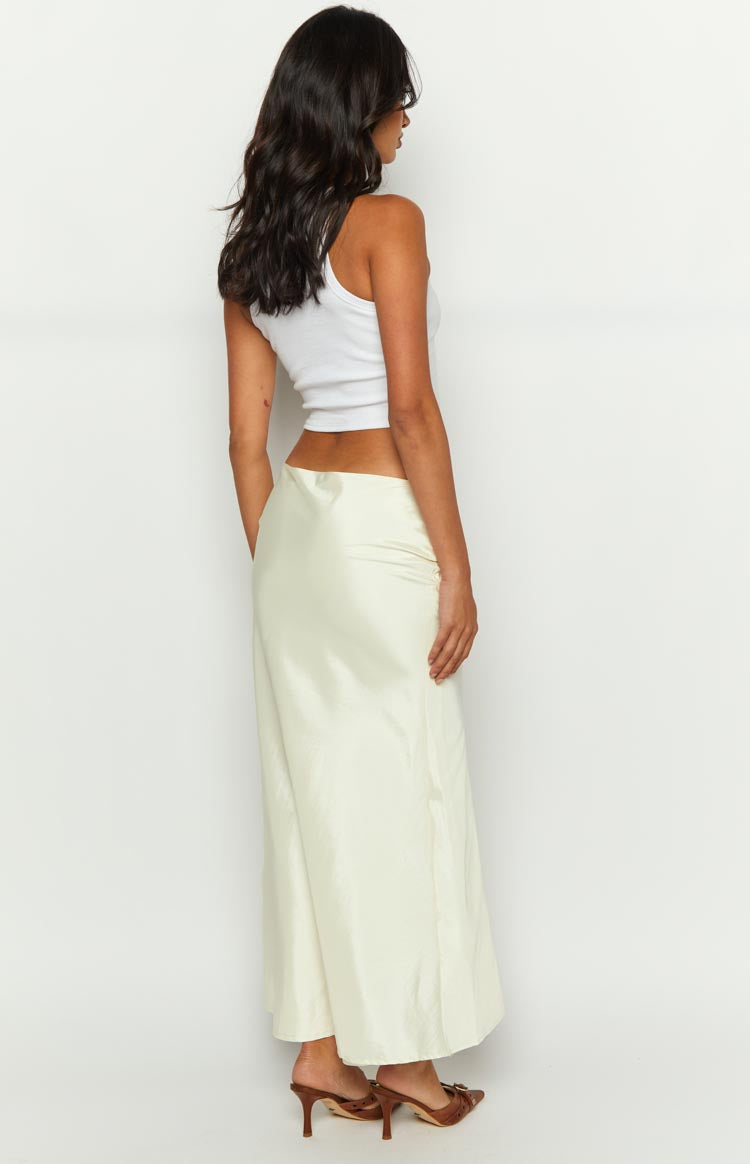 Side view of the cream maxi skirt showing its smooth, flowing fabric and floor-length hem