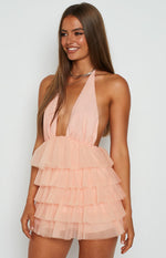 Close-up of the light pink mini dress showing the deep V-neck halter top, side cutouts, and tiered tulle skirt
