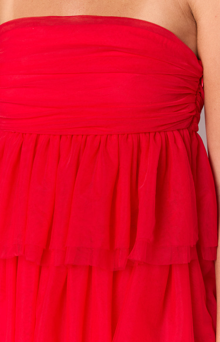 Close-up of the ruched bust and gathered tiered skirt of a red party dress